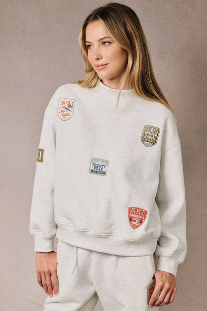 Sunday Edition by LE LIS - HIGH NECK LONG SLEEVE "SKI PATCHES" SWEATSHIRT
